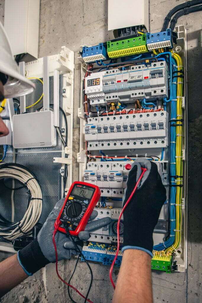 man electrical technician working switchboard with fuses